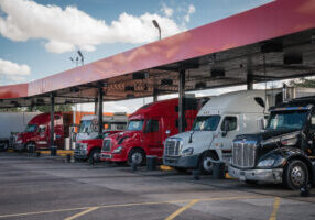 Tampa, FL, US-December 1, 2021: Row of brightly colored tractor trailer trucks at gas station.